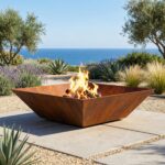 Corten steel fire pit Crystal Square on a sunny Mediterranean terrace with sea view and lavender, highlighting architectural outdoor design.