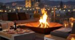 Corten steel hexagonal fire pit Diamond Hex burning wood on a modern terrace in Barcelona