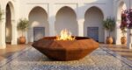 Corten Diamond Octagon TOP fire pit in an elegant Mediterranean patio with decorative flooring and architectural arches.